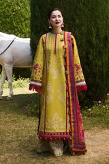 Woman in a yellow embroidered traditional outfit standing outdoors with a horse in the background.